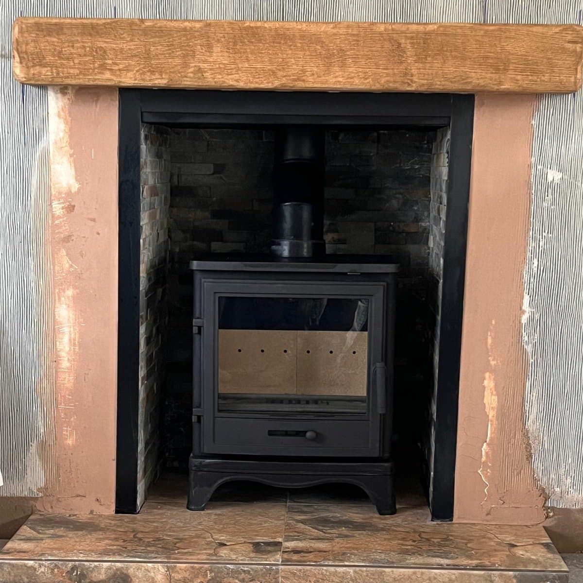 Wood burning stove on a slate hearth in a plastered chamber