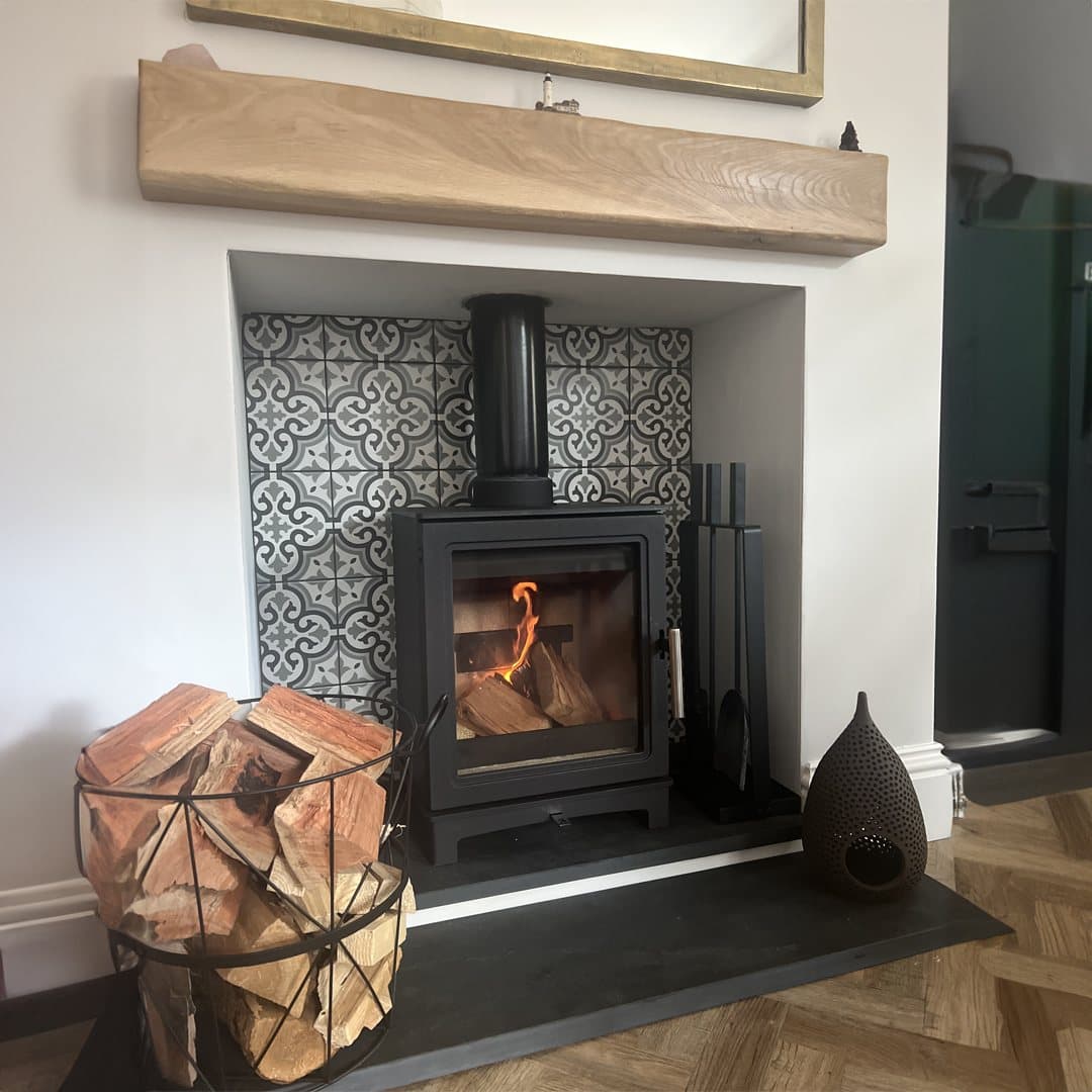 Log burner in a tiled chamber with an oak mantel and slate hearth
